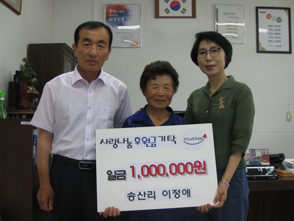 이정애씨가 100만원을 기탁한 후 김봉녀 한산면장과 함께 기념사진을 찍고 있다.
