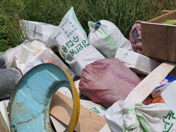 서천종합운동장 부근 버스정류장에 무단투기한 쓰레기가 방치돼 있다.