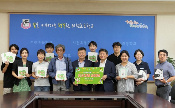 ▲뉴스서천이 서천초등학교에 도서를 기증하고 기념 촬영을 하고 있다.