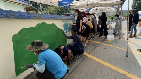 ▲구욱현 시초면주민자치위원장과 위원, 시초초 학생, 기관단체장들이 참여해 벽화를 그리고 있다.