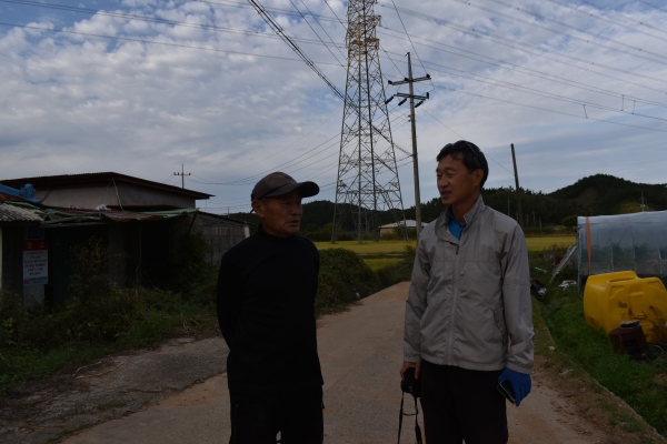 ▲송전선 피해를 말하는 마을 주민 권성동씨(왼쪽)