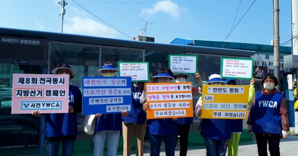▲서천 YWCA회원들이 봄의마을 버스정류장 앞에서 피켓을 들고 지방선거 캠페인을 실시하고 있다.